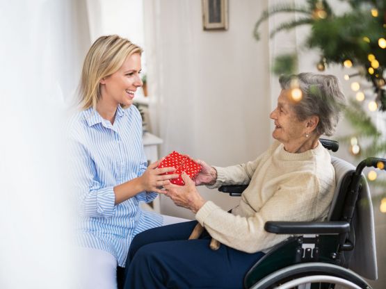 Une femme donne un cadeau à une dame âgée